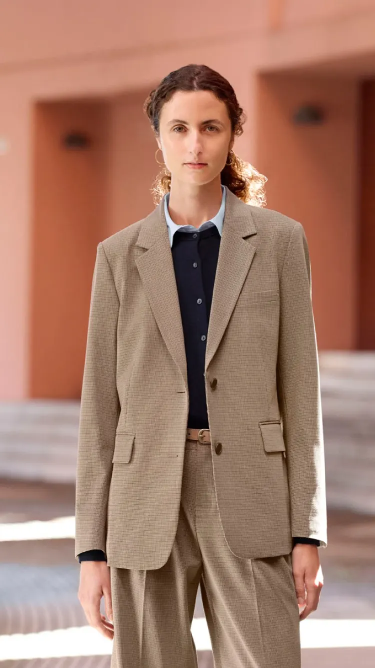 Adult model wearing a checked tan suit, layered shirt and dark top in the UNIQLO autumn collection