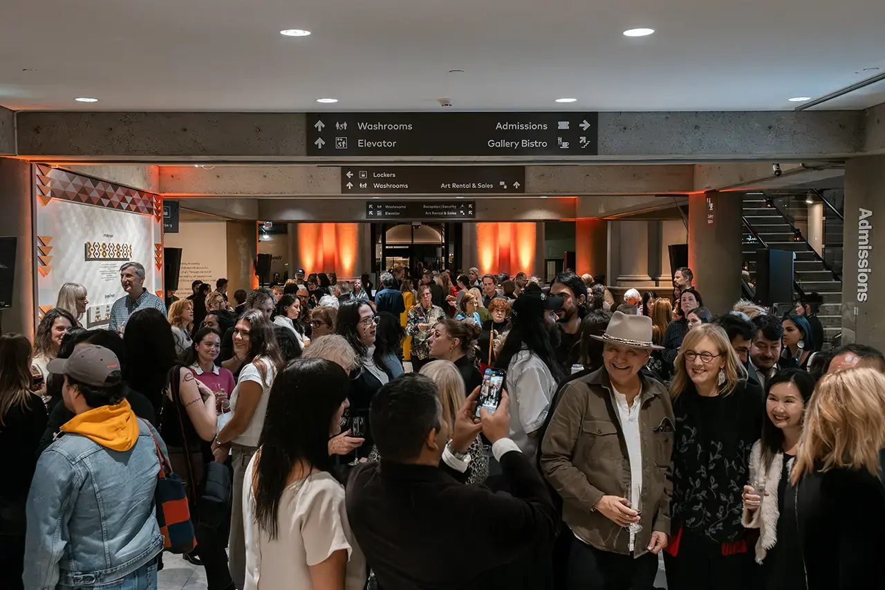 Visitors gather in an interior gallery space under warm lighting during a past Vancouver Art Gallery exhibition reception