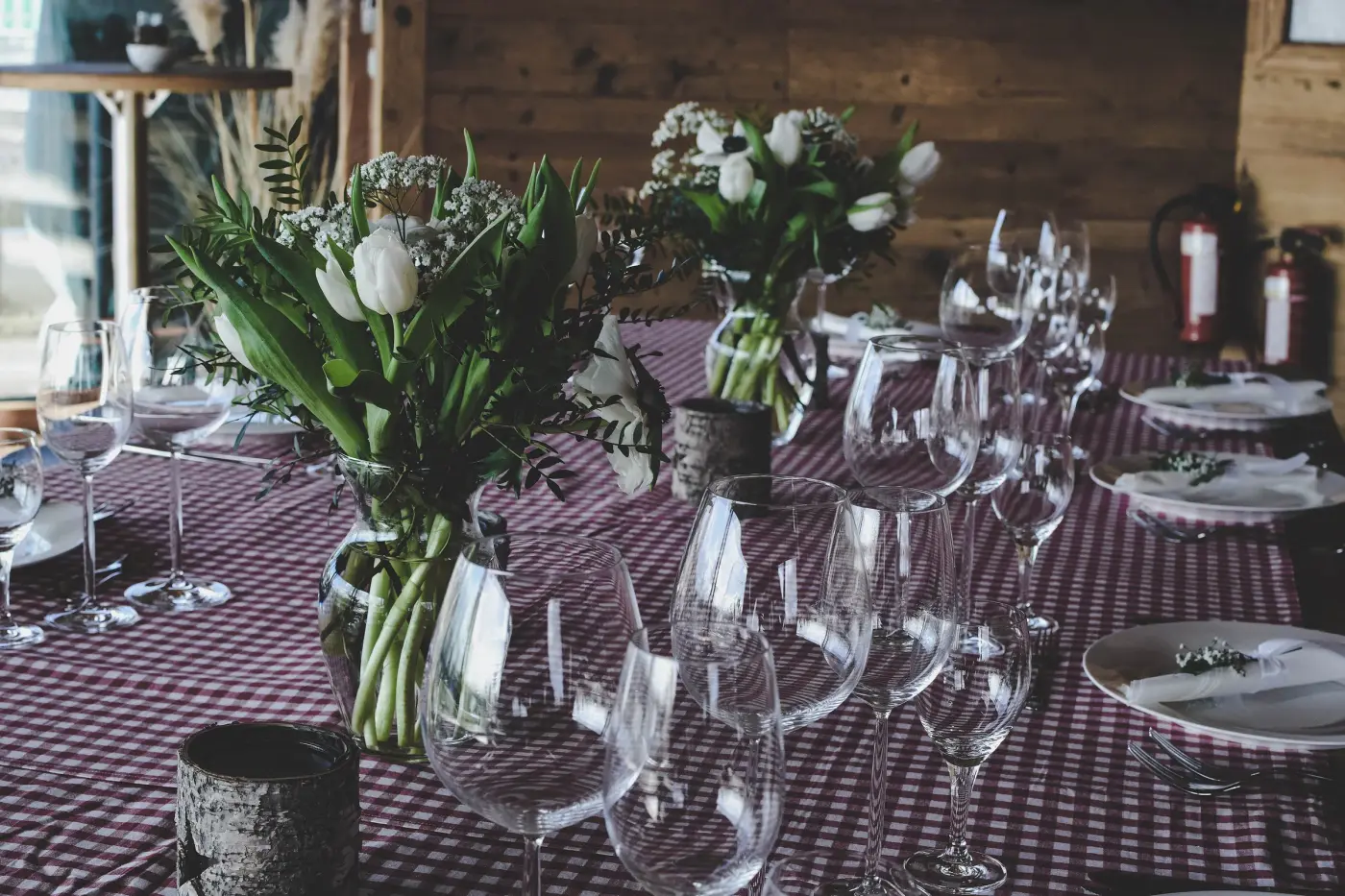A long table set with glasses and tulips for a private dinner
