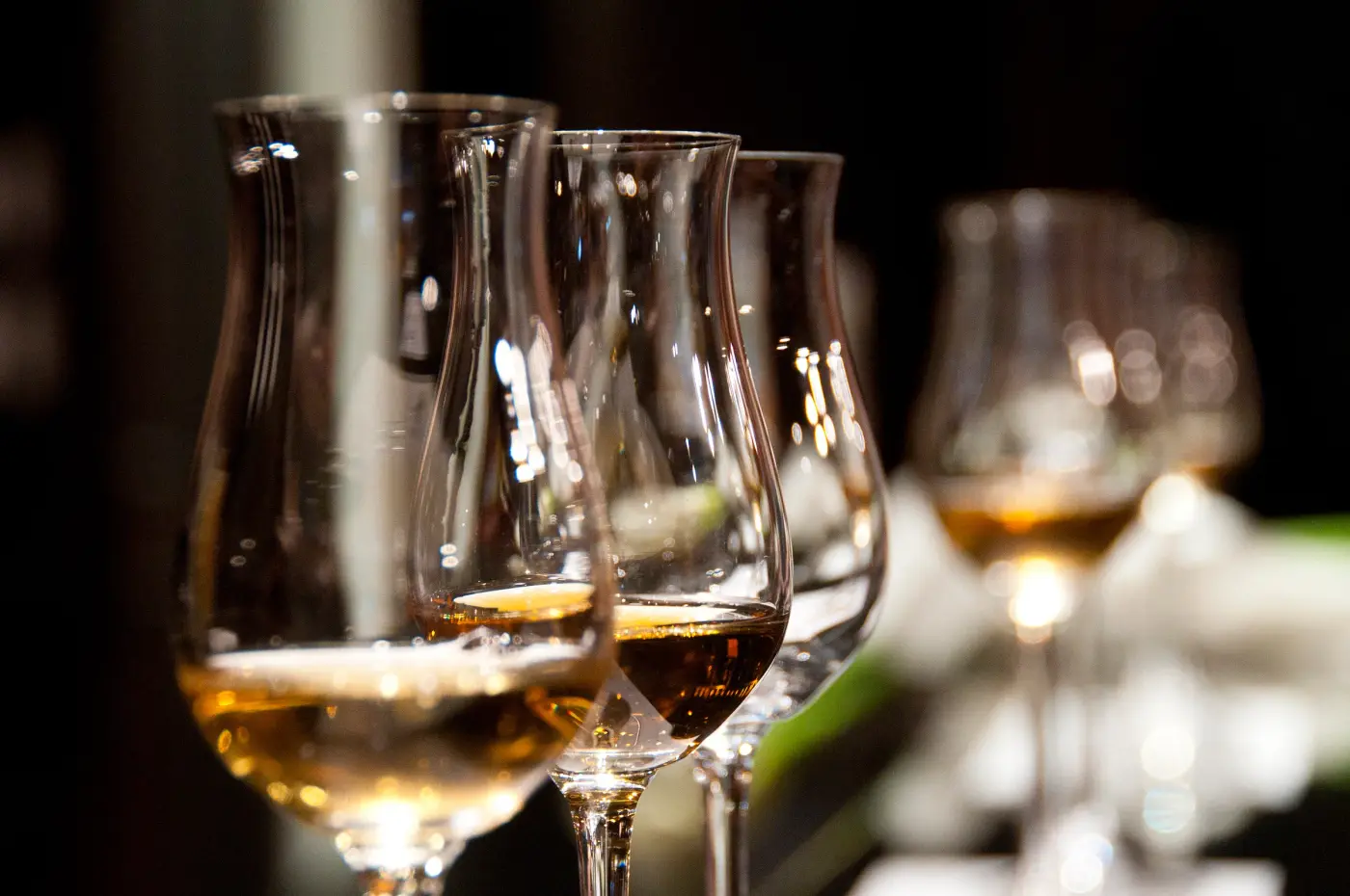 Wine glasses lined up on a candlelit table