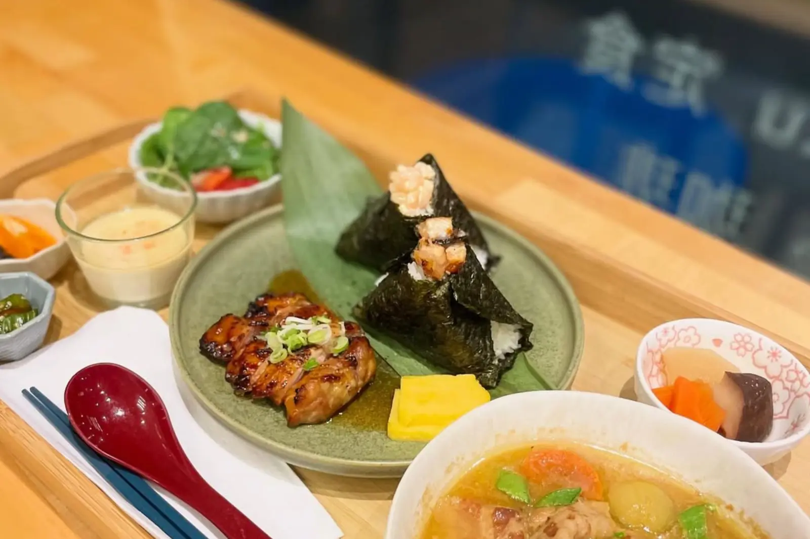 Bento Cafe food with onigiri and side dishes, shown in its expansion coverage; not the unopened Kerrisdale premises